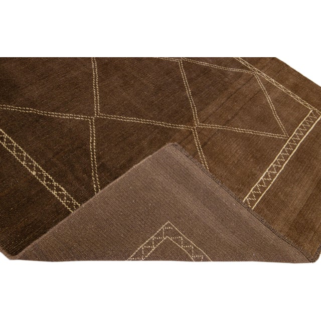 This Beautiful Moroccan-style handmade wool rug makes part of our Northwest collection and features a brown color field...