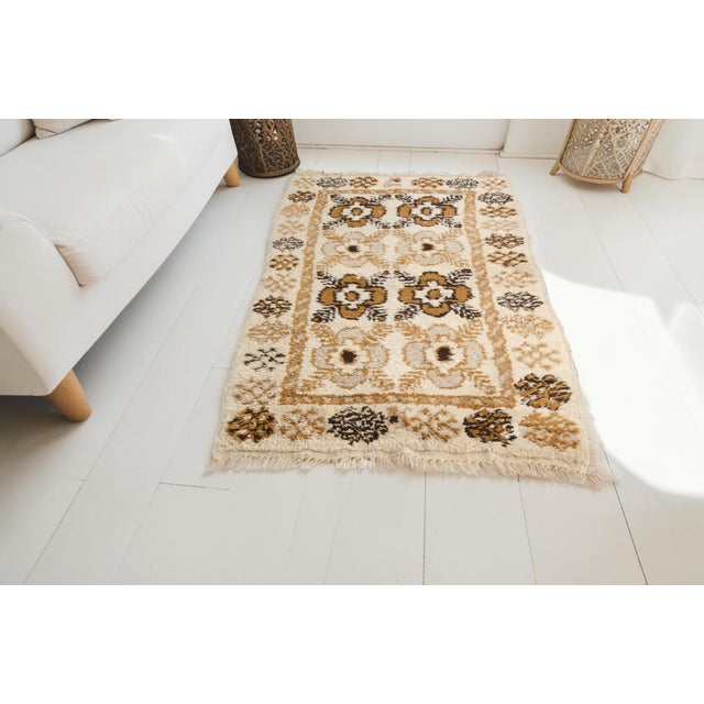 This is a vintage Turkish Oushak rug from the Mid 20th Century. The piece was hand-knotted.