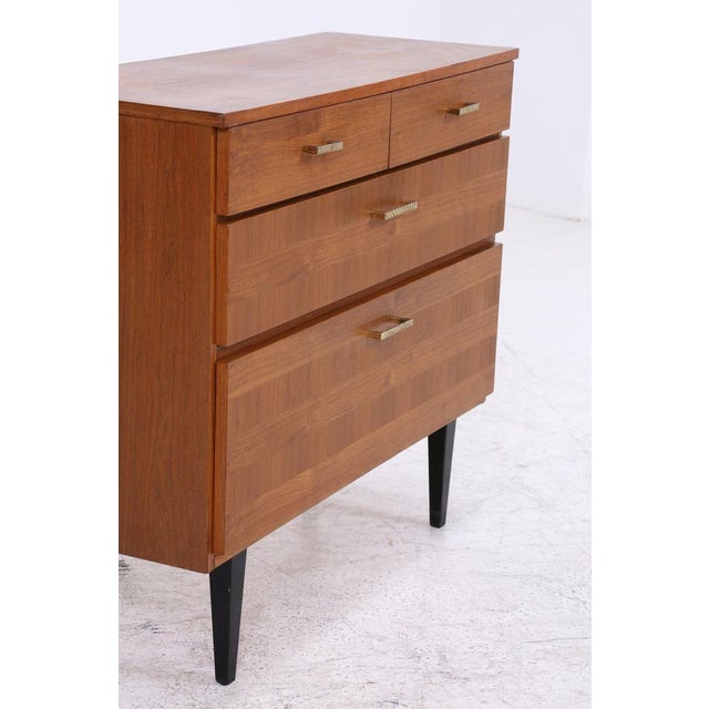 Vintage shoe cabinet from the 1960s with a practical layout and warm wood finish. Behind the two drop-down compartments is...