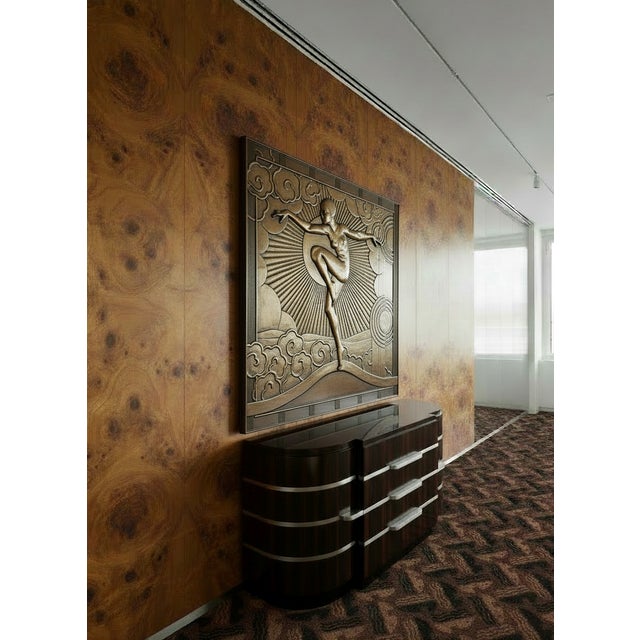 A commanding 51-inch square bas relief panel depicting a triumphant female figure in dynamic motion — arms outstretched,...