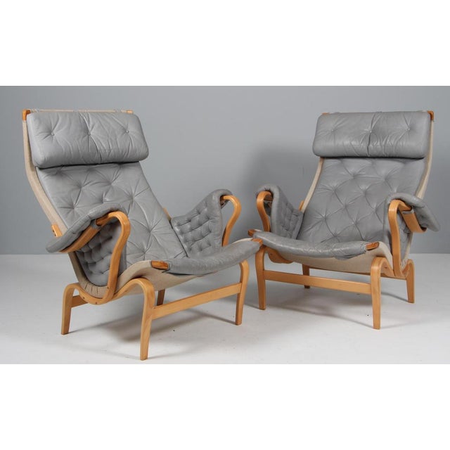Bruno Mathsson Pernilla lounge chair with patinated grey leather. Frame in beech. Made by DUX. This piece is attributed to...