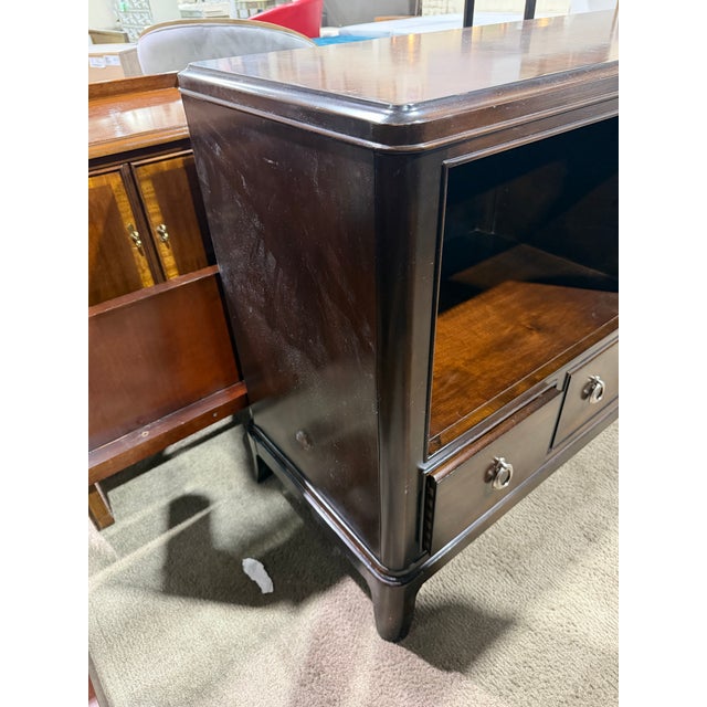 Bring classic sophistication and functional design to your living space with this Thomasville mahogany media console....