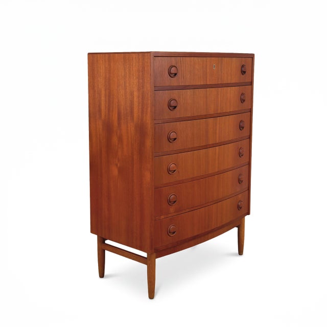 Unique mid-century modern teak dresser with rounded front and conical teak legs. Six dovetailed drawers with sculptural...
