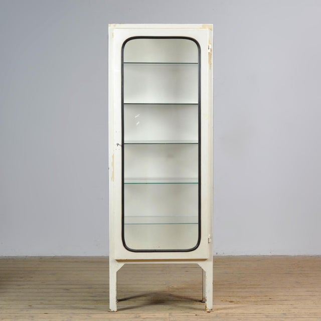 Vintage medical cabinet from the 1970s, made in Hungary. This characterful cabinet is made of iron and glass, with the...