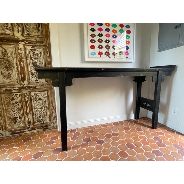 A classic Chinese altar-form console in black, with the distinctive flared wing ends and clean straight legs. The finish...