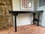 A classic Chinese altar-form console in black, with the distinctive flared wing ends and clean straight legs. The finish...