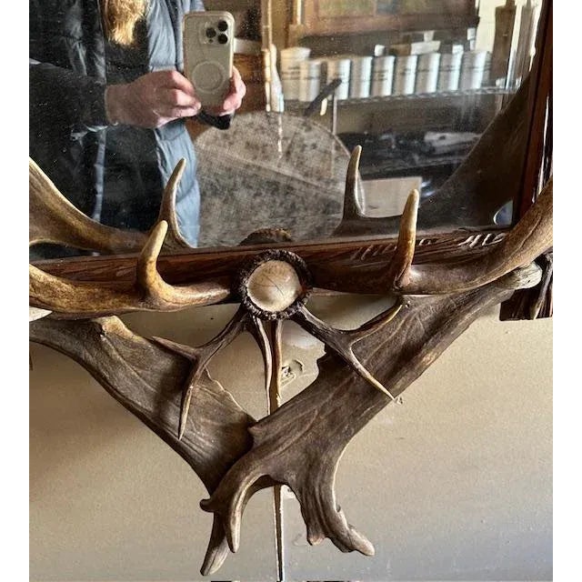 An antique German antler mirror with horns, antlers, carved rosettes, and a carved dog — arranged into a grand trophy-...