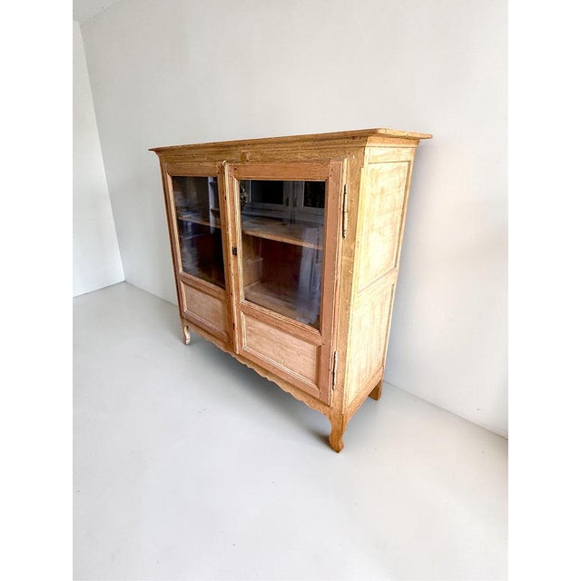 An exceptional French 19th-century glazed vaisselier (display cabinet) crafted from solid pine. This beautiful piece...