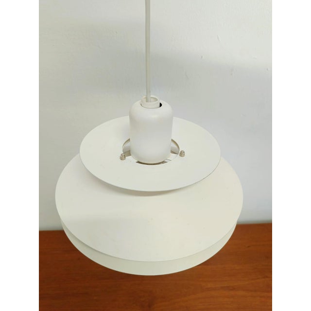 Elegant 1960s Danish pendant lamp with distinctive layered lampshades in pristine white. This iconic mid-century design...