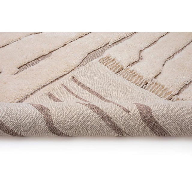 Like wind across the dunes: lines that drift, break, and begin again. Fine light taupe lines run horizontally across a...