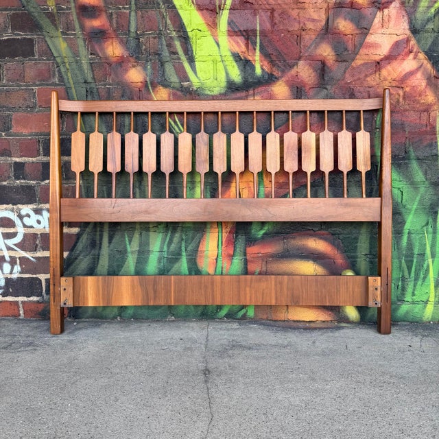 Mid Century Modern design with warm toned wood. Features a distinctive row of paddle shaped spindles set within a sturdy...