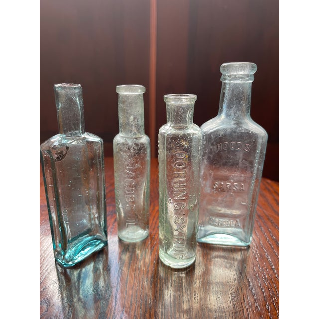 An expertly curated vignette of four authentic late 19th-century American patent medicine and apothecary bottles. This set...