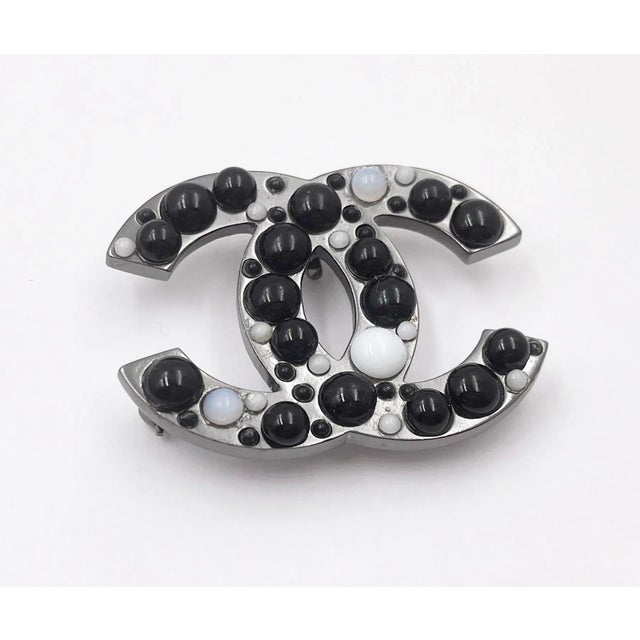 This is part of Chairish’s Costume Jewelry assortment. Chanel Gunmetal CC Black White Bead Brooch * Marked 03 * Made in...