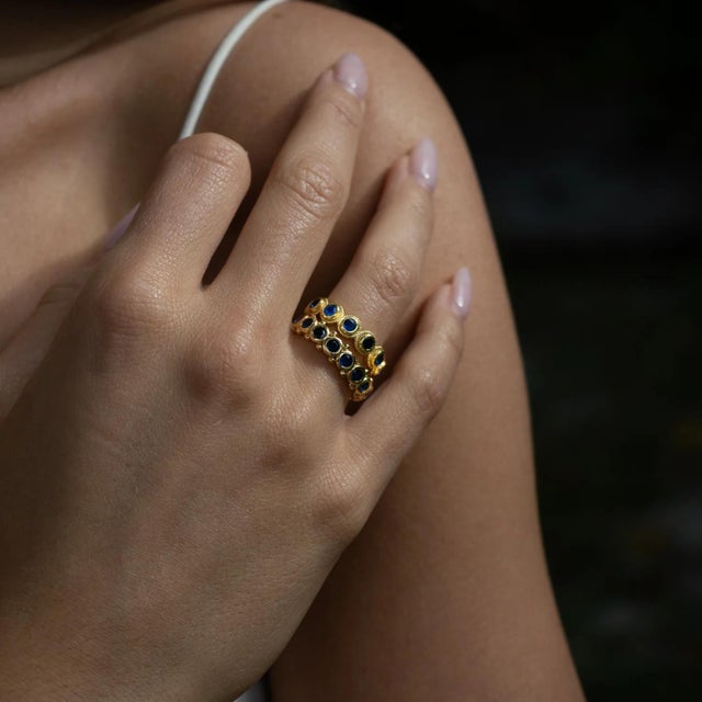 Discover sophistication with the Majestic Sapphire Adjustable Gold Statement Ring. A deep blue sapphire sparkles at the...