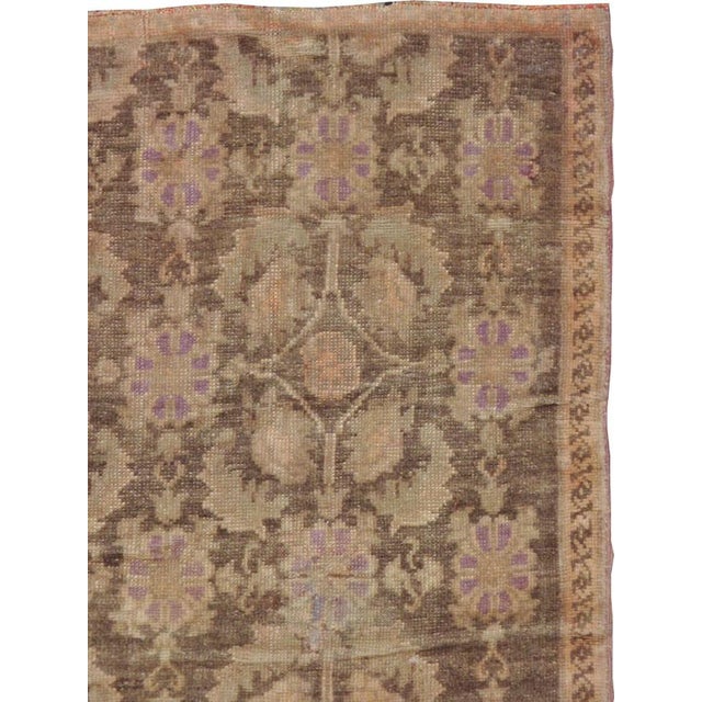 This mid-20th-century Turkish Anatolian accent rug presents a dense allover botanical pattern across a softly variegated...