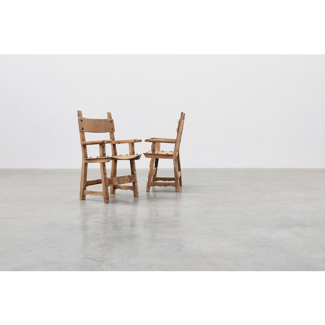 An exceptional pair of Spanish Brutalist armchairs crafted in solid wood, showcasing the bold architectural character and...