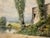 Original watercolor on paper depicting a rustic rural farmstead beside a country road, with weathered buildings, tall...