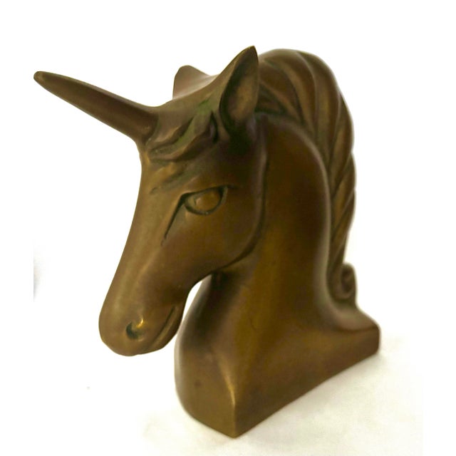 A sculptural unicorn bust with an elegantly arched neck, long tapered horn, and flowing mane that finishes in a decorative...