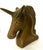 A sculptural unicorn bust with an elegantly arched neck, long tapered horn, and flowing mane that finishes in a decorative...