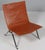 Poul Kjærholm lounge chair in patinated tan leather. Frame of brushed steel. Model PK22, made by Fritz Hansen. This piece...