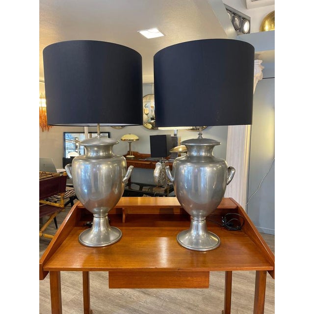 A pair of table lamps with pewter bases (silver-plated metal) shaped like classical urns or vases with side handles,...