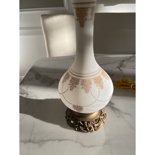 Add style to any room with this Vintage milk glass lamp trimmed with fine gold French detailing. Intricate filigree bronze...