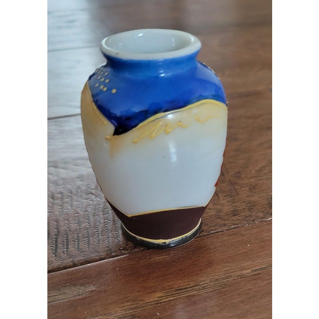 This hand decorated vase has moriage throughout. Beautiful blue sets off the gilt work. This size works well as a bud vase.