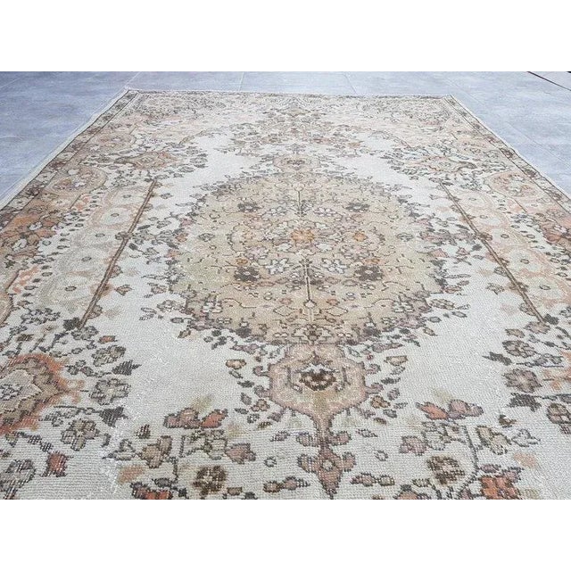 This is a vintage Turkish Oushak rug from the 1960s. The piece was hand-knotted.