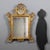 Carved and gilded mirror. Frame decorated with floral and leaf carvings, embellished with a pierced cymatium with a...