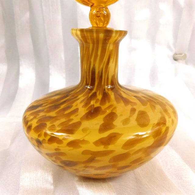 This is a cream and brown perfume bottle with a glass topper. The stopper fits very well and seals tightly and is likely...