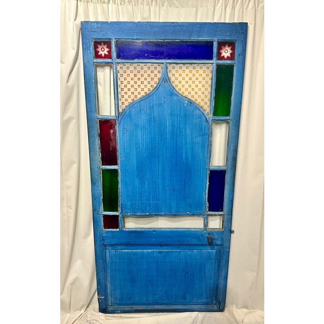 A remarkably decorative antique architectural salvage door featuring a striking Moorish-inspired silhouette, vibrant...