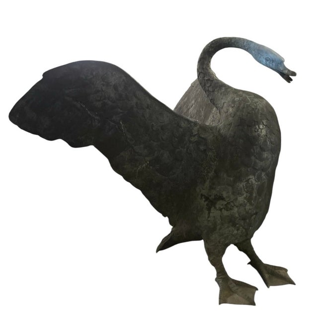 A commanding and elegantly weathered bronze sculpture of a swan in mid-display, featuring an impressive wingspan and a...