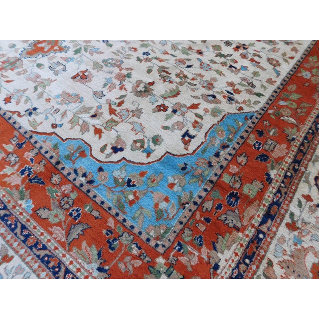 Central medallion on an ivory field, surrounded by floral decoration. Ivory border displaying floral decoration. Wool pile...