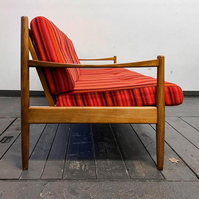 Product. 3 seater sofa style. Mid-century · 1960s material. In solid beech · dark stained · red striped upholstery fabric...
