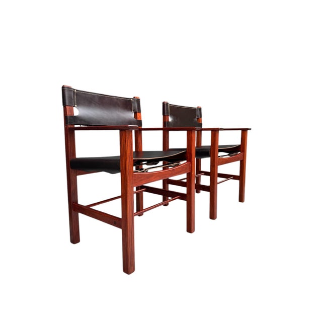 Pair of vintage mid-century modern leather and wood Spanish/safari style armchairs by Ligna. Featuring a thick slung...