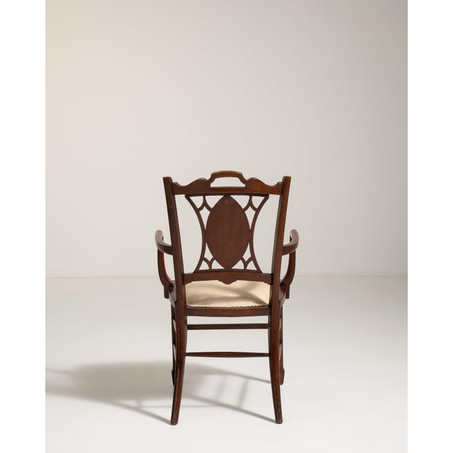 A refined Edwardian inlaid armchair crafted in richly toned mahogany, representing the transition from late Victorian...