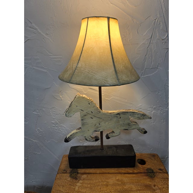 A wonderful mid-to-late 20th-century primitive folk art table lamp styled after a historic running horse weathervane. The...