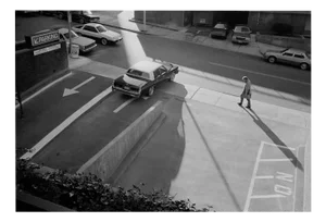 Michael Ormerod, Man Walking Past Parking Lot, Photographic Print