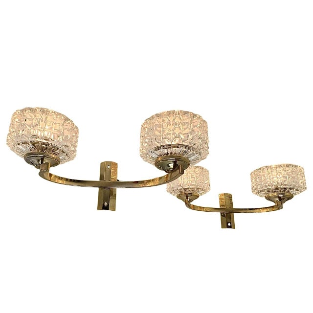 A set of French Mid-Century double sconces made of brass with clear glass. Attractive and warm ambient lighting. They are...
