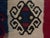 Vintage Turkish flat-weave kilim textile roll. Features repeating traditional tribal medallions woven onto a bold, solid...