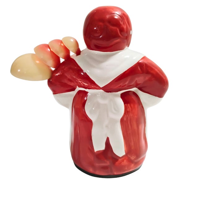 This 6-inch tall vintage ceramic container depicts a classic mid-century kitchen figurine and measuring spoon holder. The...