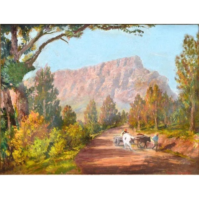 Farmers guide a cart pulled by cows along a dirt path, a majestic mountain is their backdrop; a scene from South Africa....