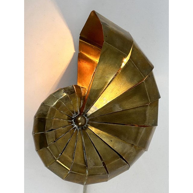 Unique, elegant and highly decorative mid-century modern brass sconce or light object 'natilius'. Designed & manufactured...