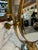 Charming vintage vanity mirror featuring a classic round brass frame with elegant curved supports and a decorative...