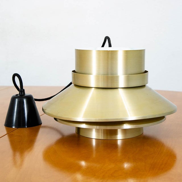 Tiered brass Danish pendant light fixture. Metallic exterior with a matte white interior. Unmarked example. Beautiful and...