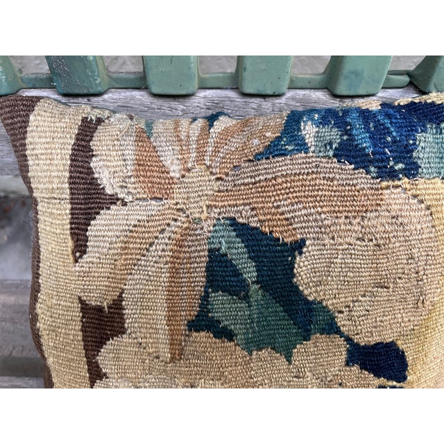 This charming decorative pillow is upholstered with an authentic 18th-century tapestry featuring a delicate floral motif....
