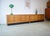 This is a modular walnut sideboard from the 1960s. The sideboard features a slim, floor-to-ceiling design with four doors....