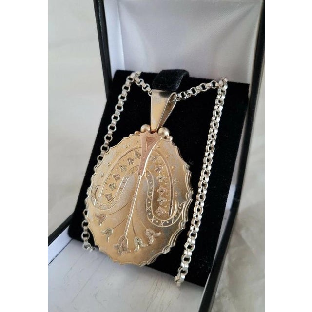A charming late Victorian sterling silver oval locket and chain dating to circa the 1890s, displaying the distinctive...