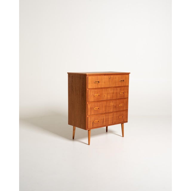Vintage Scandinavian teak chest of drawers with four large drawers and recessed handles with oak frames and turned legs....