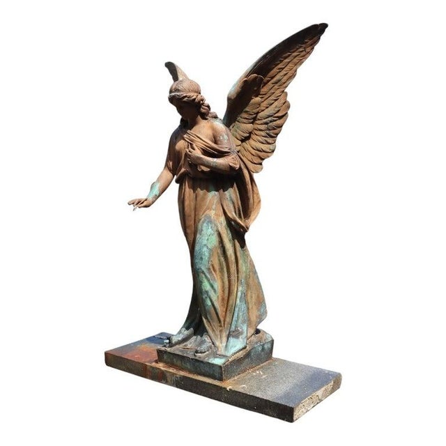 This antique classical garden sculpture features a winged angel crafted from zinc, mounted on a substantial marble base....